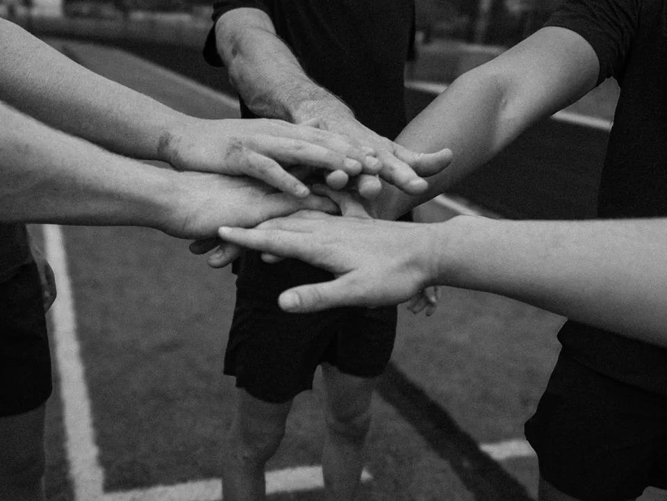 Klomper teammates joining hands before training